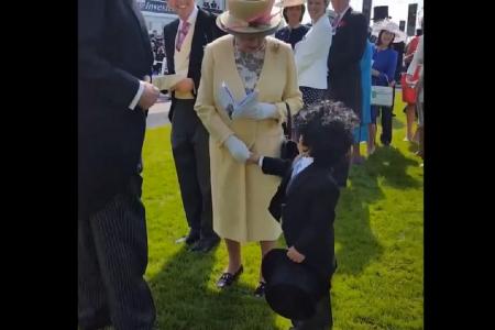 Boy in a top hat shows the world how to be a gentleman in front of the Queen