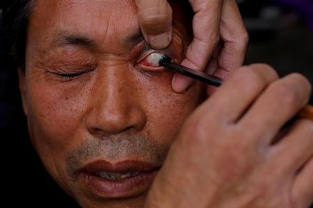Street barber performs traditional eyelid shave