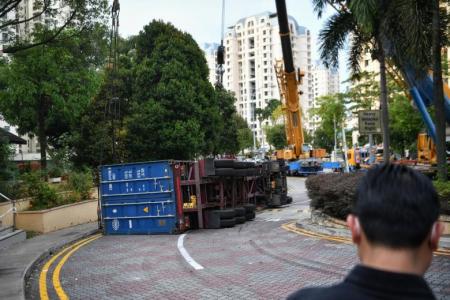 Container truck overturns along narrow road in Bedok, driver taken to hospital
