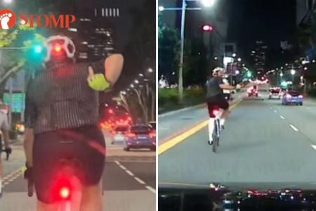 Cyclist flashes middle finger at driver 3 times, uses phone while riding on Orchard Road