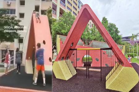 Child stuck atop 3m-high playground structure, woman tries to help him down with bamboo pole