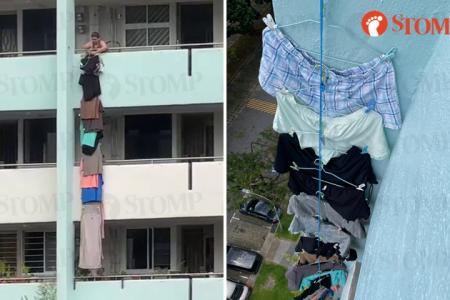 Woman hangs laundry down multiple floors of AMK block