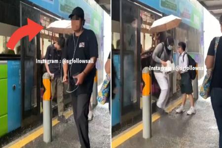 What a lad: Schoolboy shelters alighting bus passengers with umbrella amid pouring rain