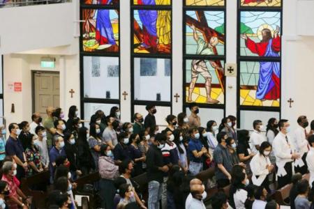 Crowds donning masks pack pews and sing hymns in churches on Good Friday