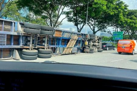 Trailer truck carrying concrete slabs tips over and lands on its side after accident in Sheares Avenue