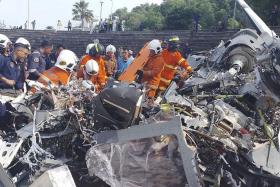 Fire and rescue officers working at the scene where helicopters crashed at the Royal Malaysian Navy base in Perak on April 23.