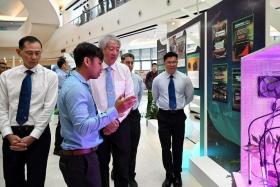 Senior Minister  Teo Chee Hean (third from left) being introduced to a mock-up of household cannabis cultivation at the Central Narcotics Bureau Workplan Seminar on May 3, 2023.