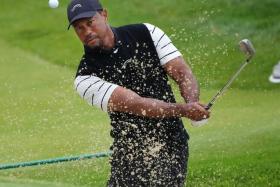 Tiger Woods hits a bunker shot on the third green during a practice round for the PGA Championship.