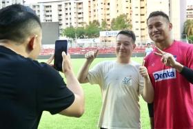 Hassan Sunny (right) posing for a photo with a fan after a training session at Jurong East Stadium on June 13. 