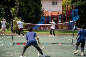 Loh Kean Yew (left) and his brother Kean Hean playing badminton with kids at the Pertapis Children&#039;s Home.