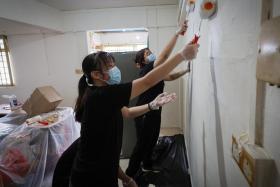 NYP student Gloria Chua (left) repainting a rental flat in Ang Mo Kio as part of Project Rejuven-Aid on Nov 3.