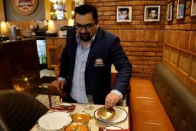 FILE PHOTO: Amit Bagga, CEO of Daryaganj restaurant, shows a freshly prepared butter chicken dish and the lentil dish Dal Makhani inside Daryaganj restaurant at a mall, in Noida, India, January 23, 2024. REUTERS/Sahiba Chawdhary/File Photo