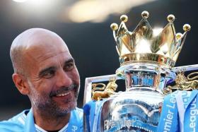 Soccer Football - Premier League - Manchester City v West Ham United - Etihad Stadium, Manchester, Britain - May 19, 2024  Manchester City manager Pep Guardiola celebrates with the trophy after winning the Premier League Action Images via Reuters/Lee Smith