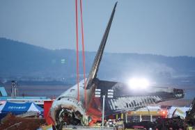 Efforts are made to lift the wreckage of an aircraft lying on the ground after it went off the runway and crashed at Muan International Airport, in Muan, South Korea on Dec 29.