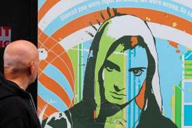 FILE PHOTO: A man looks at an artwork depicting Irish singer Sinead O'Connor, who died at the age of 56, known for her chart-topping hit 'Nothing Compares 2 U', in Dublin, Ireland, July 27, 2023. REUTERS/Damien Storan/File Photo