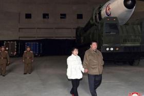 KCNA did not name the girl, who is seen holding hands with her father as they look at the massive missile. 