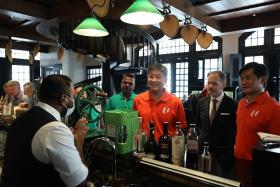 NTUC secretary-general Ng Chee Meng (centre) and NTUC deputy secretary-general Desmond Tan (right) at the Long Bar, Raffles Hotel Singapore on Nov 6. 