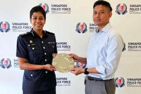 Commander Airport Police Division, Assistant Commissioner of Police M Malathi, presents the Public Spiritedness Award to Mr Helmi Ali.