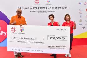 President Tharman Shanmugaratnam receiving a cheque of $250,000 from Ms Low Yen Ling (centre), Senior Minister of State for Culture, Community and Youth, and Trade and Industry, and People’s Association assistant chief executive Jeanie Tan.