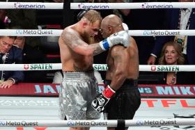 Mike Tyson (right) and Jake Paul hug after Paul defeated Tyson in their heavyweight boxing bout.