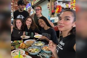 Dua Lipa (right) posted a photo of herself and her crew, as well as the local dishes they tucked into, on social media on Nov 6.