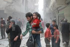 BLOODY CONFLICT: A man in the Aleppo district of Ansari, Syria, carrying a child and making his way through rubble following air strike reports.