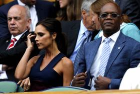 Victoria Beckham and US actor Samuel L Jackson sitting in the Royal Box on Centre Court before the start of the men&#039;s singles final match of the 2014 Wimbledon Championships on July 6, 2014. 