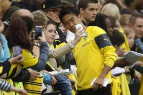 WELCOME BACK: Dortmund&#039;s Japanese playmaker Shinji Kagawa (above) posing for photos with fans after a training session.
