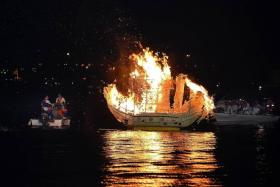 SMOKE ON THE WATER: Wishes of devotees are pasted on a boat made of paper, which is then set ablaze and sent to the sea.