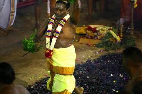 FAITH: Head priest of the Sri Mariamman Temple K. Swaminathan walking on hot coal at the fire-walking festival.