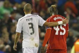 Liverpool&#039;s Mario Balotelli walks off the pitch at half-time with Real Madrid&#039;s Pepe, before swapping shirts in the tunnel, during their Champions League Group B soccer match at Anfield in Liverpool.
