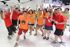 PUMPED UP: Mr Low Han Thong (front, in orange), Huawei Singapore&#039;s head of devices, said Huawei is proud to be part of The New Paper Big Walk 2014.