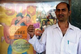A man posing with his movie ticket ahead of a screening of the popular Bollywood Hindi film 'Dilwale Dulhania Le Jayenge' (The Brave hearted Will Take The Bride Away) at the Maratha Mandir cinema in Mumbai.