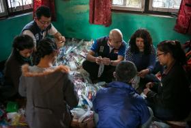 REACHING OUT: (Above) Mr Michael Tay (centre, in blue) and his team packing relief supplies in Nepal’s Bagmati Zone.