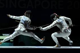 Singapore&#039;s Wang Wenying (right) duels with Justine Gail Tinio of the Philippines during the women&#039;s individual foil final at the 28th SEA Games.