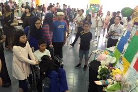SAYING GOODBYE: Emyr Uzayr (with bandage) and El Wafeeq El Jauzy (in wheelchair) at the Tribute Corner at Tanjong Katong Primary School with their families.