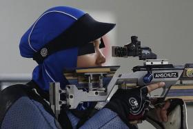 DRESSED FOR SUCCESS: Nur Ayuni Farhana (above) shooting her way to the gold medal.  