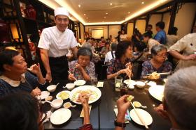 Qi Yuwu serving up his meal for members of the Pioneer Generation