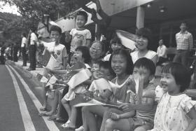 Madam Yeo Soo Hoon, and her 12 grandchildren watching the National Day Parade in 1985