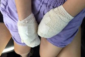 ACCIDENT: Jayna Tan, three, cut her hands after she dropped a glass jar of mayonnaise at FairPrice Xtra in Kallang Wave Mall. Staff member Joanne Phua helped to carry Jayna to a clinic, which was a 10-minute walk away.