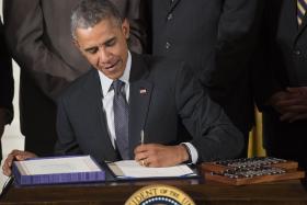 US president Barack Obama uses his favoured left hand to sign the  H.R. 1295 Trade Preferences Extension Act of 2015 two months ago.