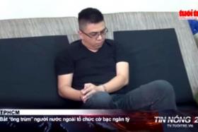 RAIDED: A screenshot of a Vietnamese TV new report showing Mr Lawrence Wong in handcuffs.