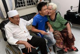 HAPPY: Mohamed Afiq Mohamed Aris, 16, with his grandparents, Mr Hussein Ahmad and Madam Asian Dollah. 