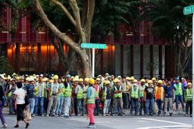 ALL SAFE: (above) Workers from the construction site were evacuated to a grass patch  along Wallich Street.
