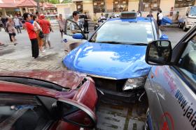 A Comfort taxi trying to reverse into a parking space at an open-air carpark at Bedok North St 2 suddenly mounted the kerb at high speed and rammed into an elderly woman.