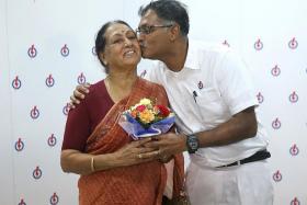 ELECTED: (Above)  Mr Murali Pillai giving his mother, Madam Vasanthi Ramadass, a bouquet of flowers and a kiss after the press conference.