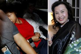 Indonesian maid Dewi Sukowati, wearing a red polo T-shirt, in a police car on 20 March 2014. She was charged with the murder of socialite and philanthropist Nancy Gan Wan Geok.