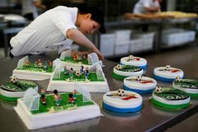 ADDING ICING: A confectioner preparing Euro 2016-themed cakes in Munich.