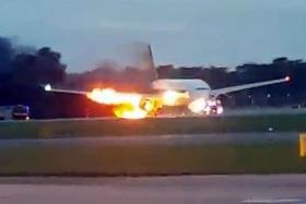 ABLAZE: (Above) The right wing of the plane caught fire after landing. 