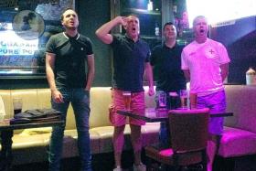 HIGH BEFORE THE LOW: England fans singing their national anthem with gusto at McGettigan&#039;s in Clarke Quay yesterday morning before the team&#039;s shambolic 2-1 loss to Iceland.